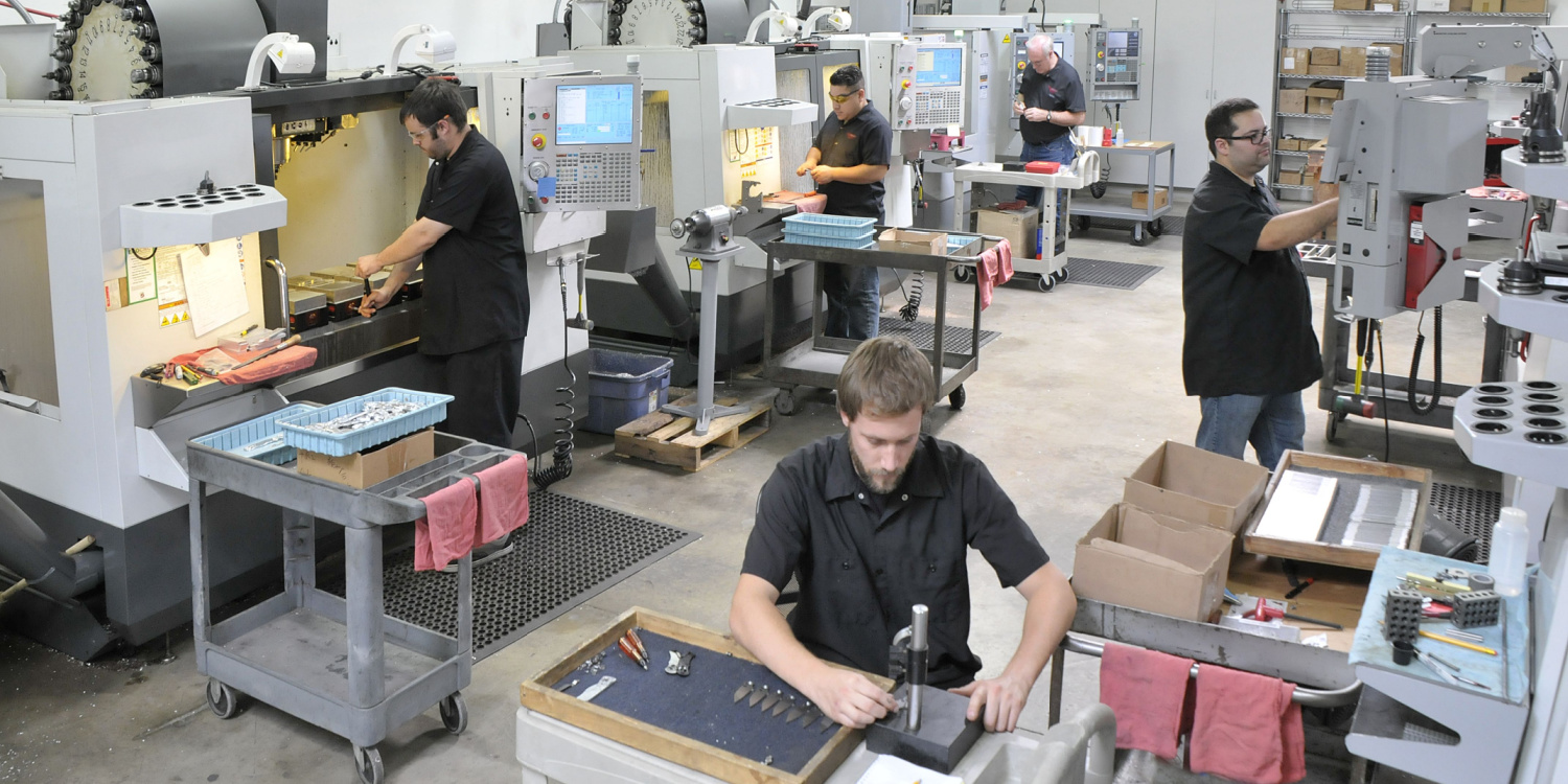 A busy machine shop with engineers and technicians.