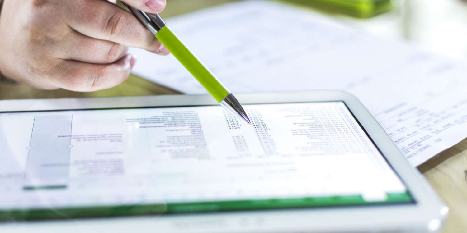 An estimator looks over a spreadsheet of costs on a tablet.